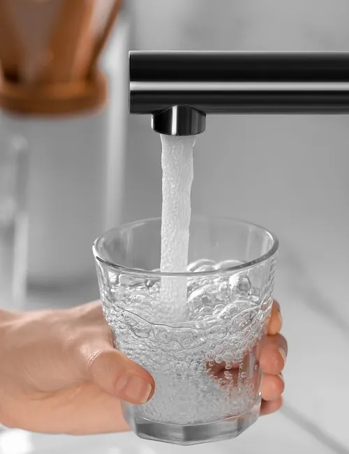 Person filling a glass of water
