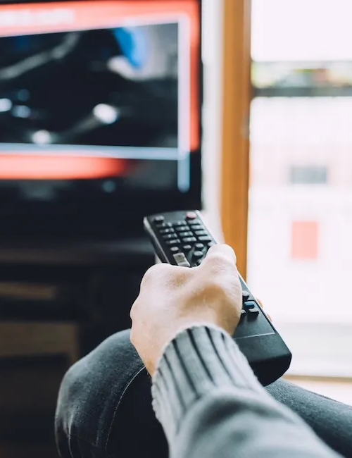 Person holding remote control towards tv